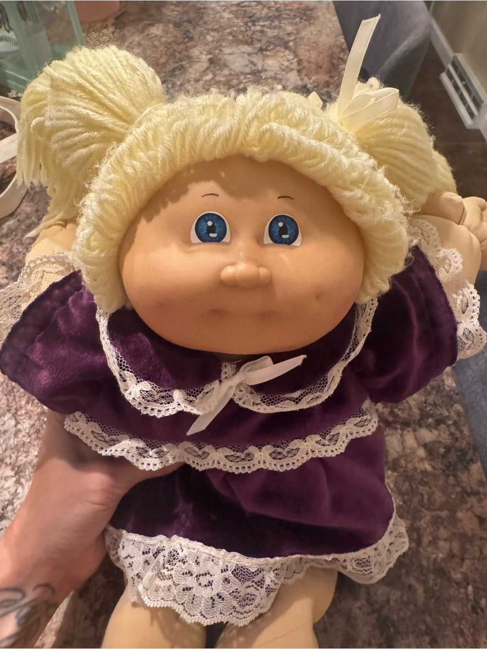 A Cabbage Patch Kid doll with blonde yarn hair and a purple dress - Picture 10 of 11